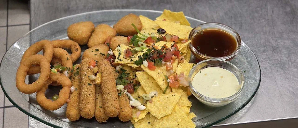 Crispy platter with nachos, onion rings and dips